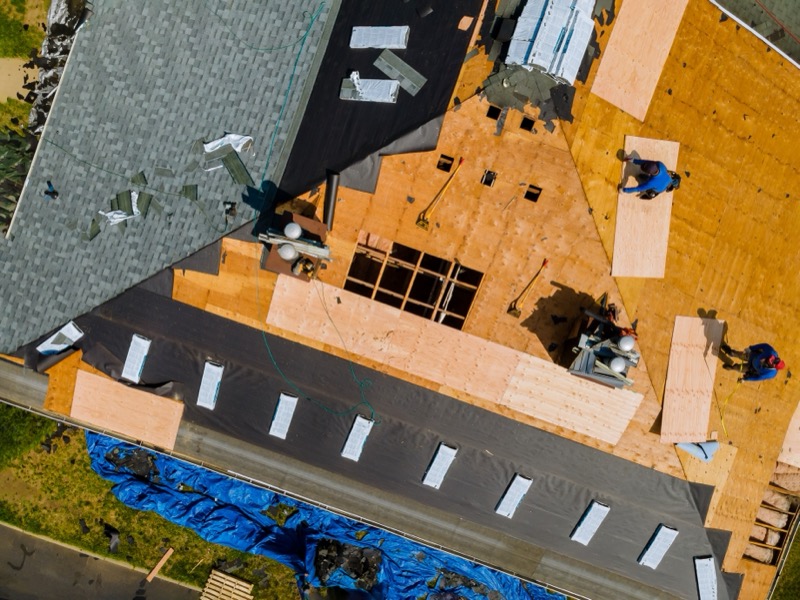Professional roofer installing shingles with precision air gun